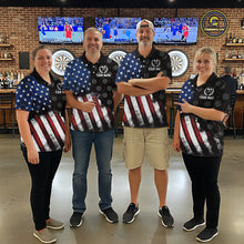 Load image into Gallery viewer, Group of darts players wearing matching custom black polo shirts with distressed US flag graphics, posing together in a sports bar setting