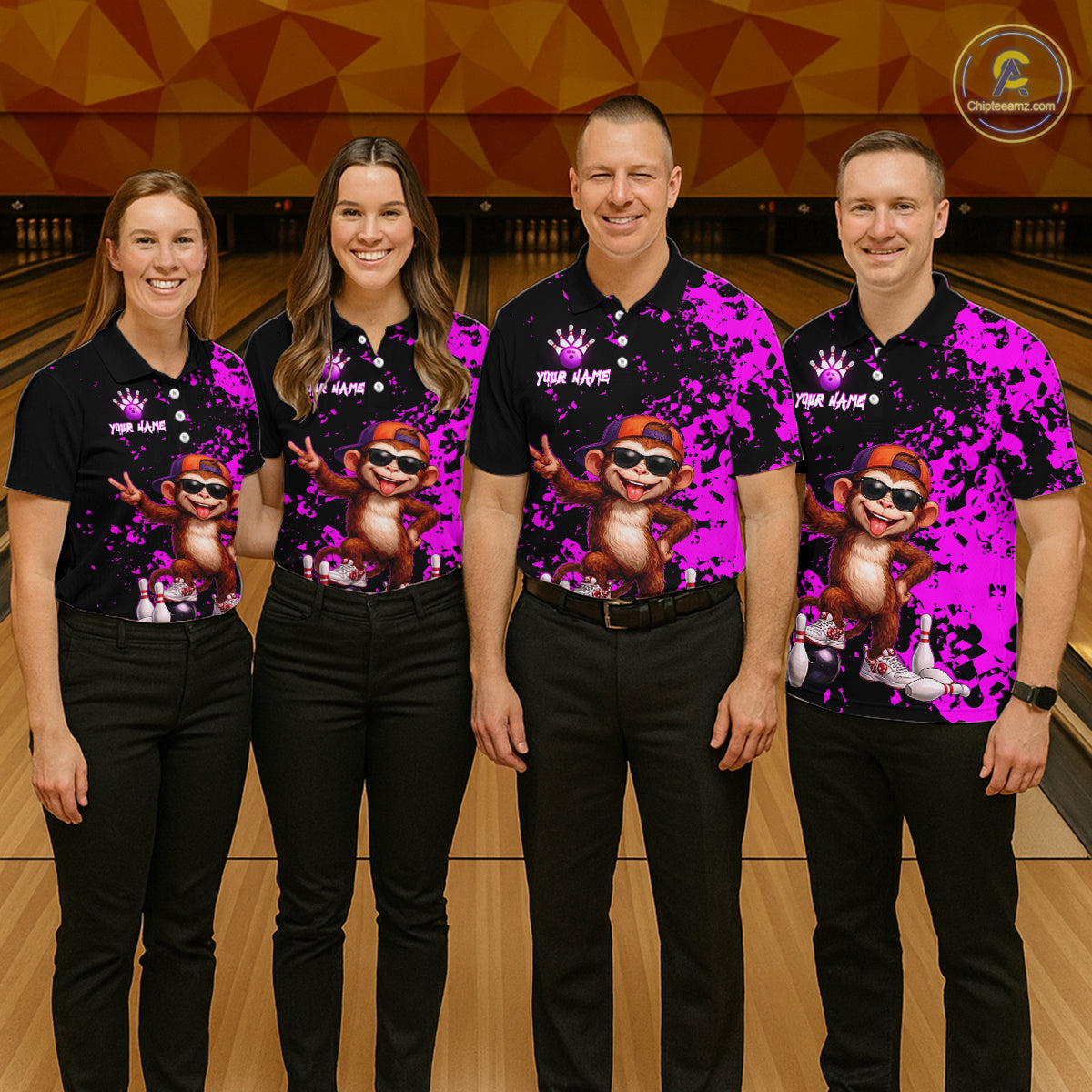 Four people standing in a bowling alley wearing matching black polo shirts with a bright pink and purple splatter design, featuring a cartoon monkey wearing sunglasses.