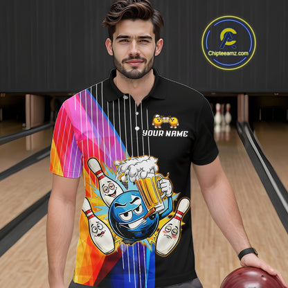 Man wearing a black t-shirt with colorful graphics and text, holding a bowling ball in a bowling alley.