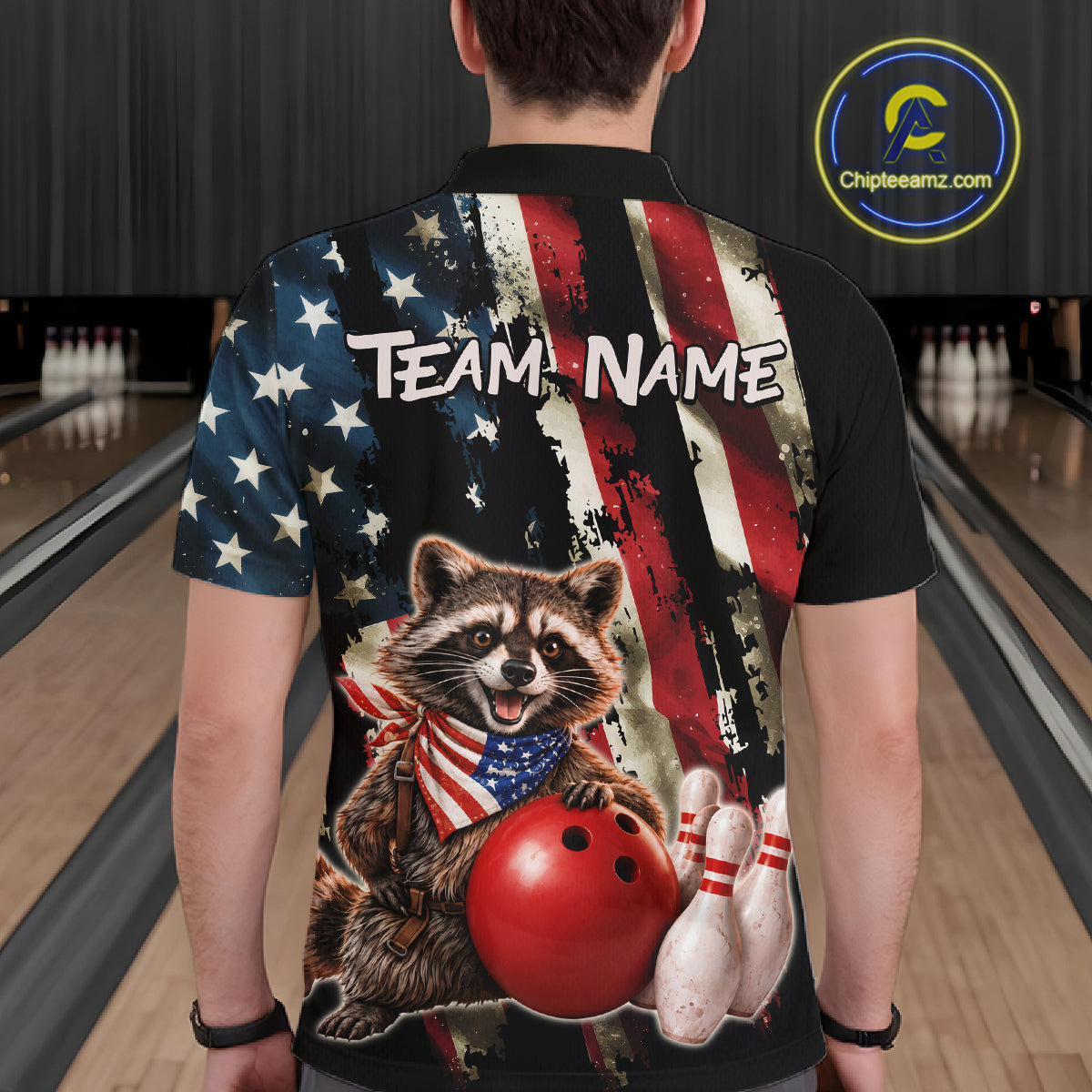 Person wearing a bowling-themed shirt with a raccoon graphic in a bowling alley.