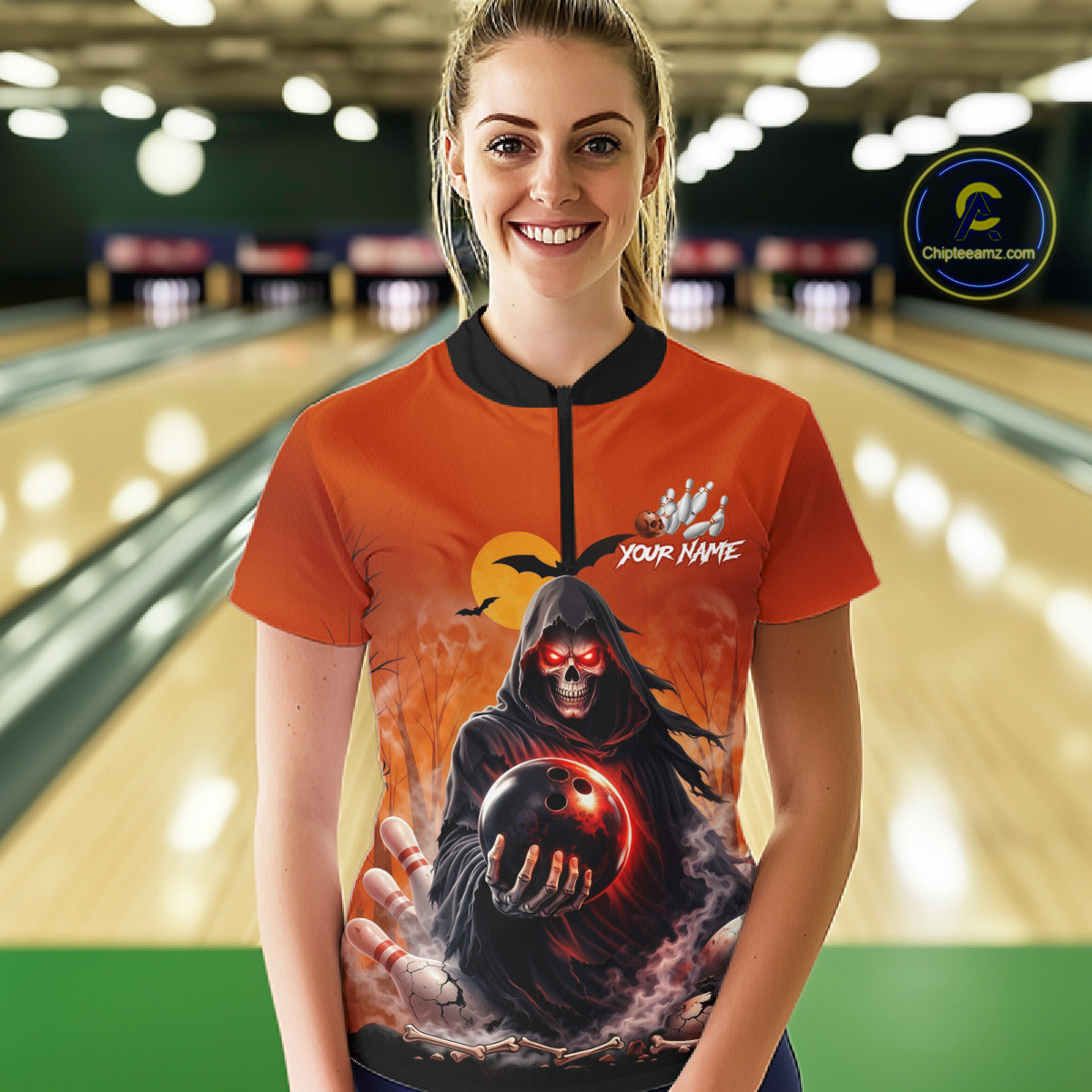 Female model wearing a custom orange grim reaper bowling quarter-zip shirt front view featuring a hooded grim reaper, glowing bowling ball, fiery smoke effect and sunset background at the bowling alley