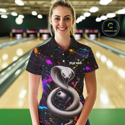 Woman wearing a colorful bowling shirt with a snake design in a bowling alley.