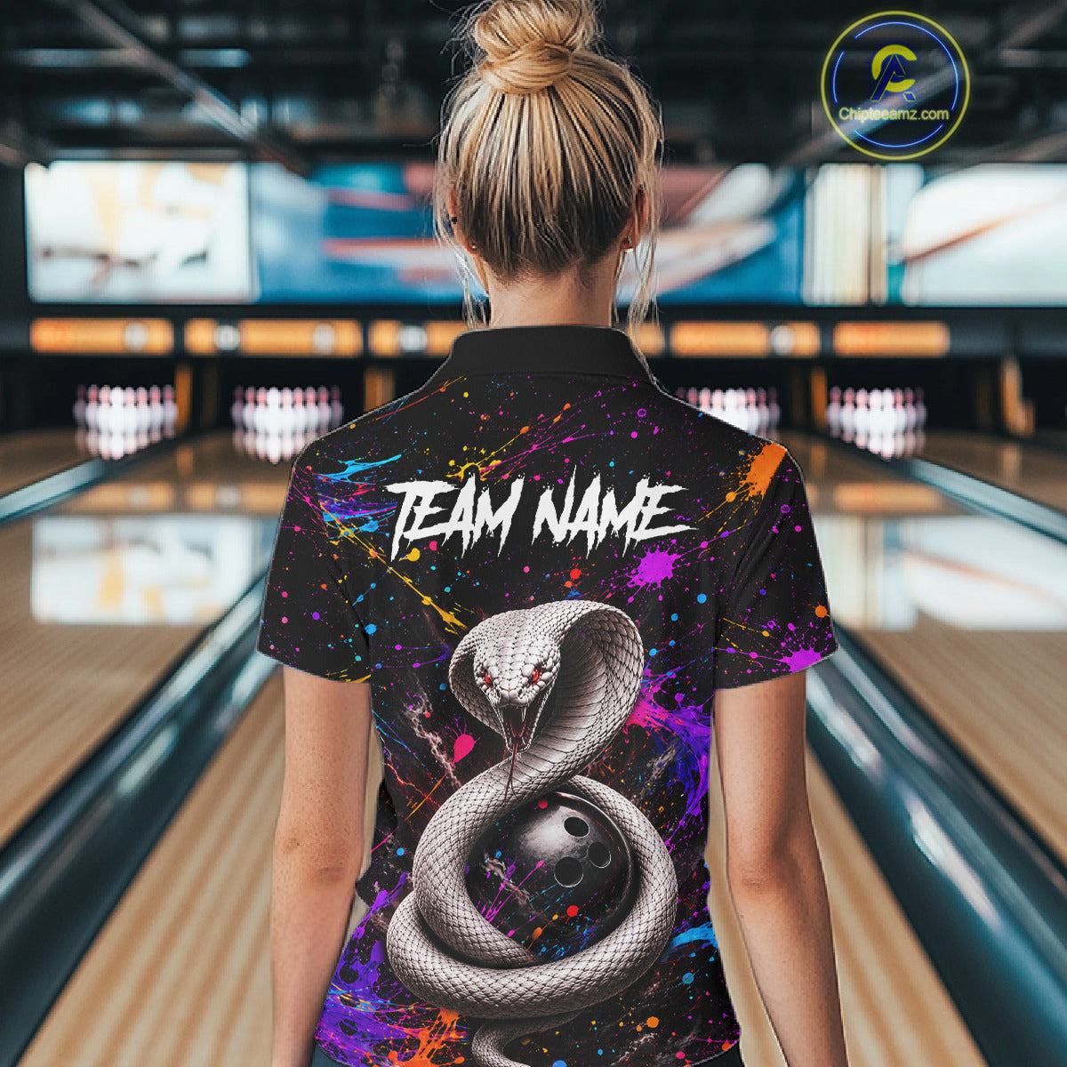 Person wearing a colorful bowling shirt with a snake design and 'TEAM NAME' text in a bowling alley.