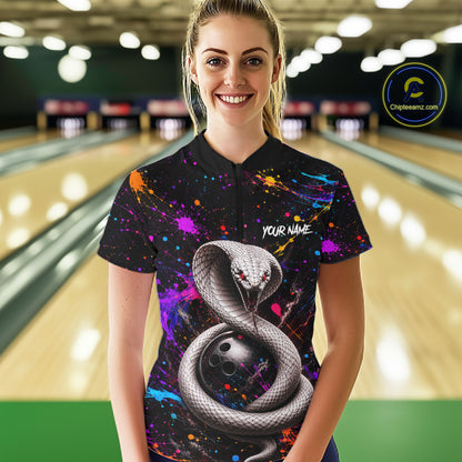 Woman wearing a colorful bowling shirt with a snake design in a bowling alley.