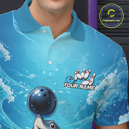 A close-up of a person wearing a bright blue short-sleeve polo shirt with a bowling-themed graphic print, including a bowling ball, pins, waves, and placeholder text reading 'YOUR NAME'. 