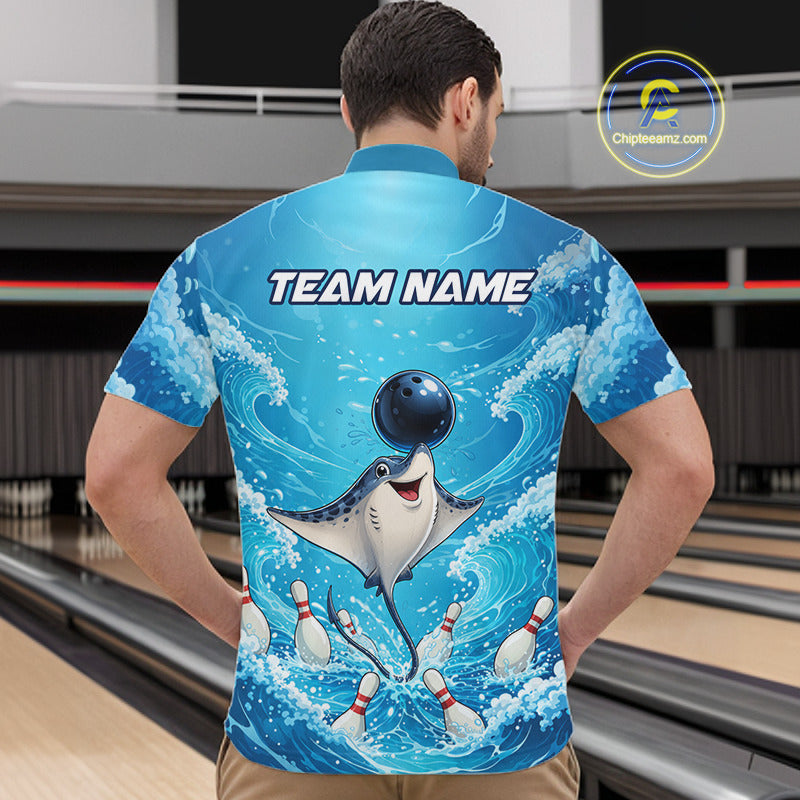 A man viewed from behind wearing a short-sleeve bowling shirt with a blue ocean wave graphic, a cartoon stingray catching bowling pins, a bowling ball on his head, and the text 'TEAM NAME' across the upper back. Bowling lanes are visible in the background