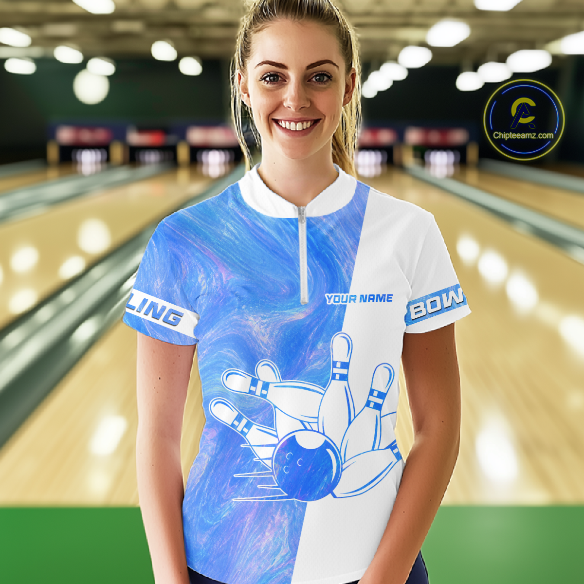 Woman wearing a blue and white bowling jersey with a bowling alley in the background