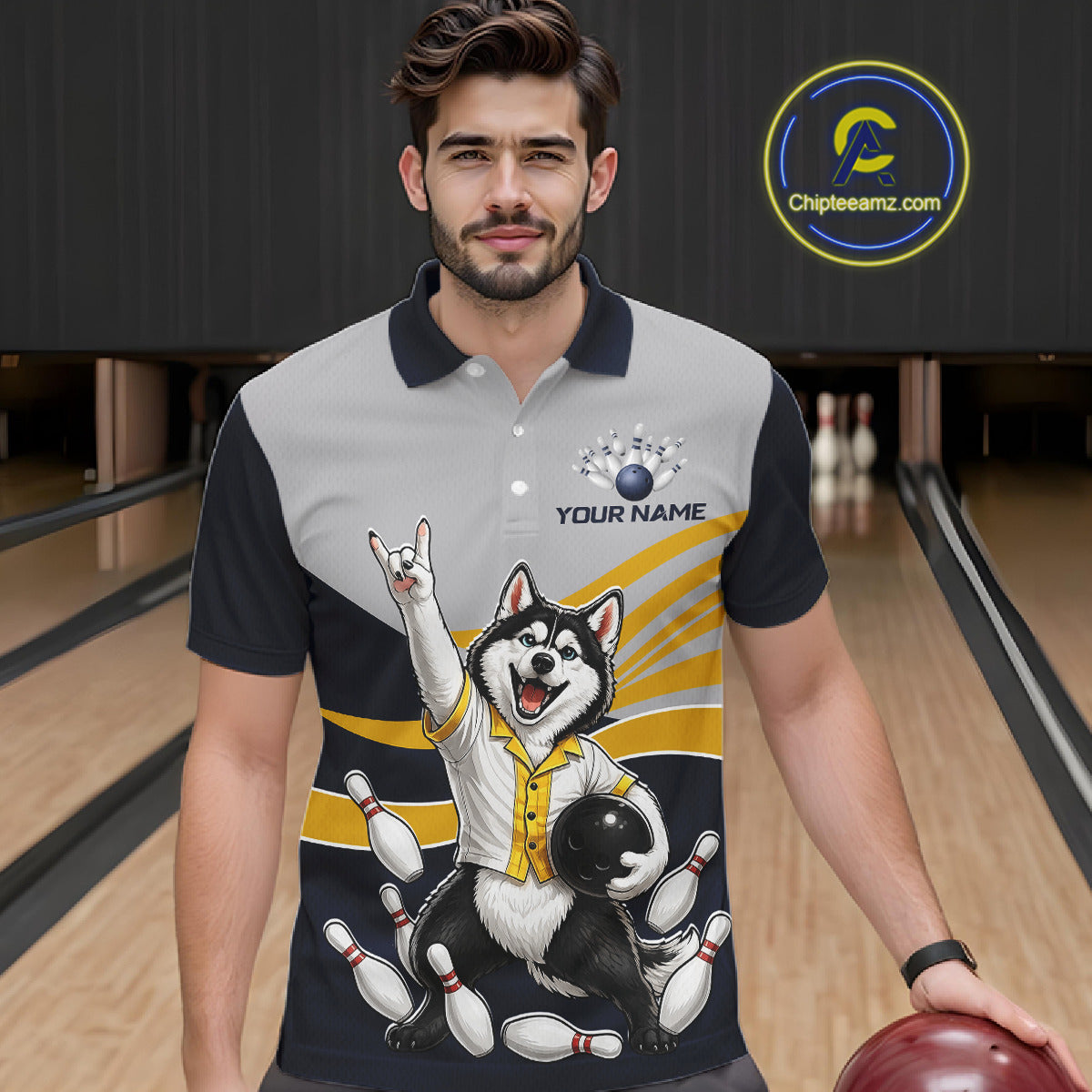 Man wearing a bowling-themed shirt with a dog graphic in a bowling alley.