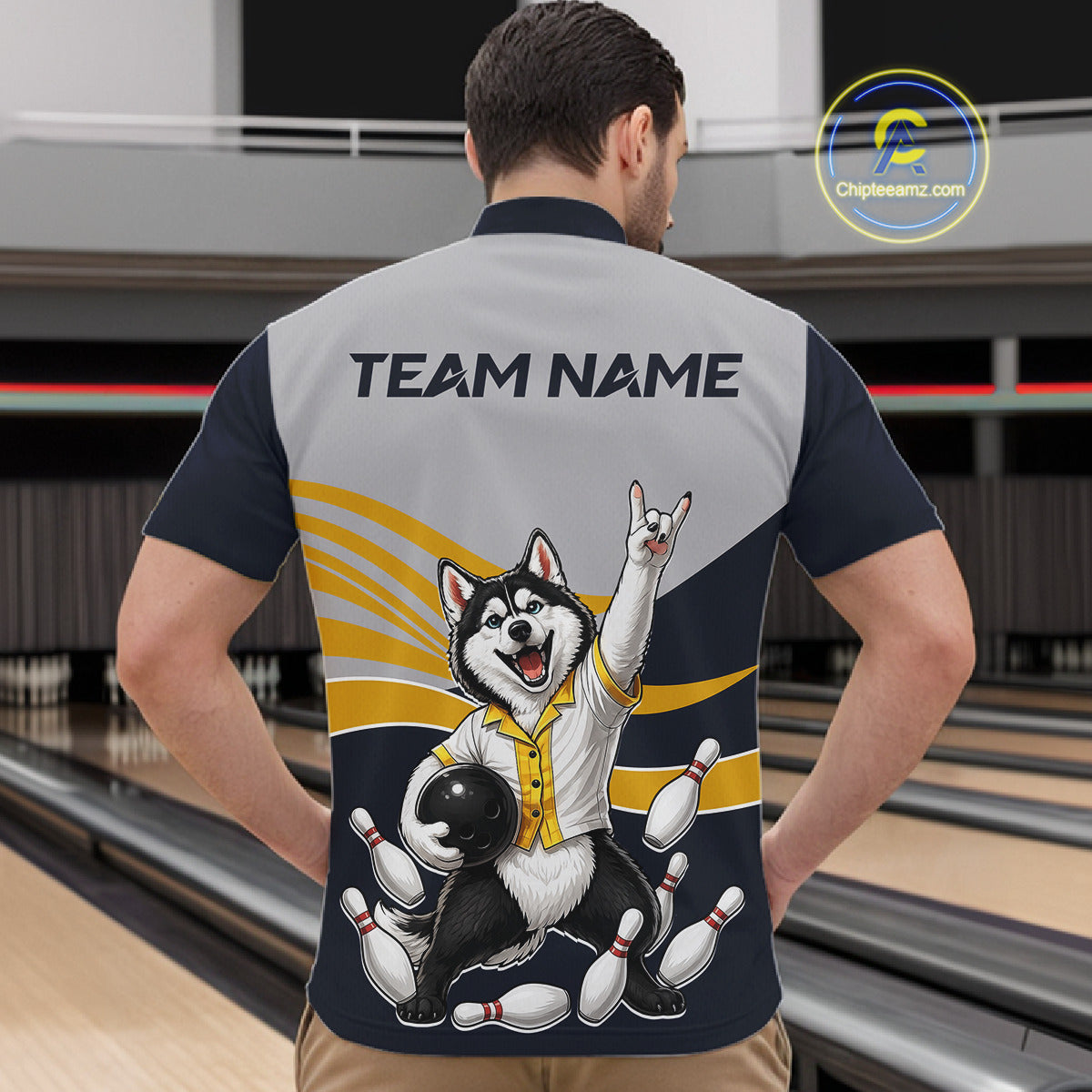 Person wearing a bowling-themed shirt with a dog graphic in a bowling alley.