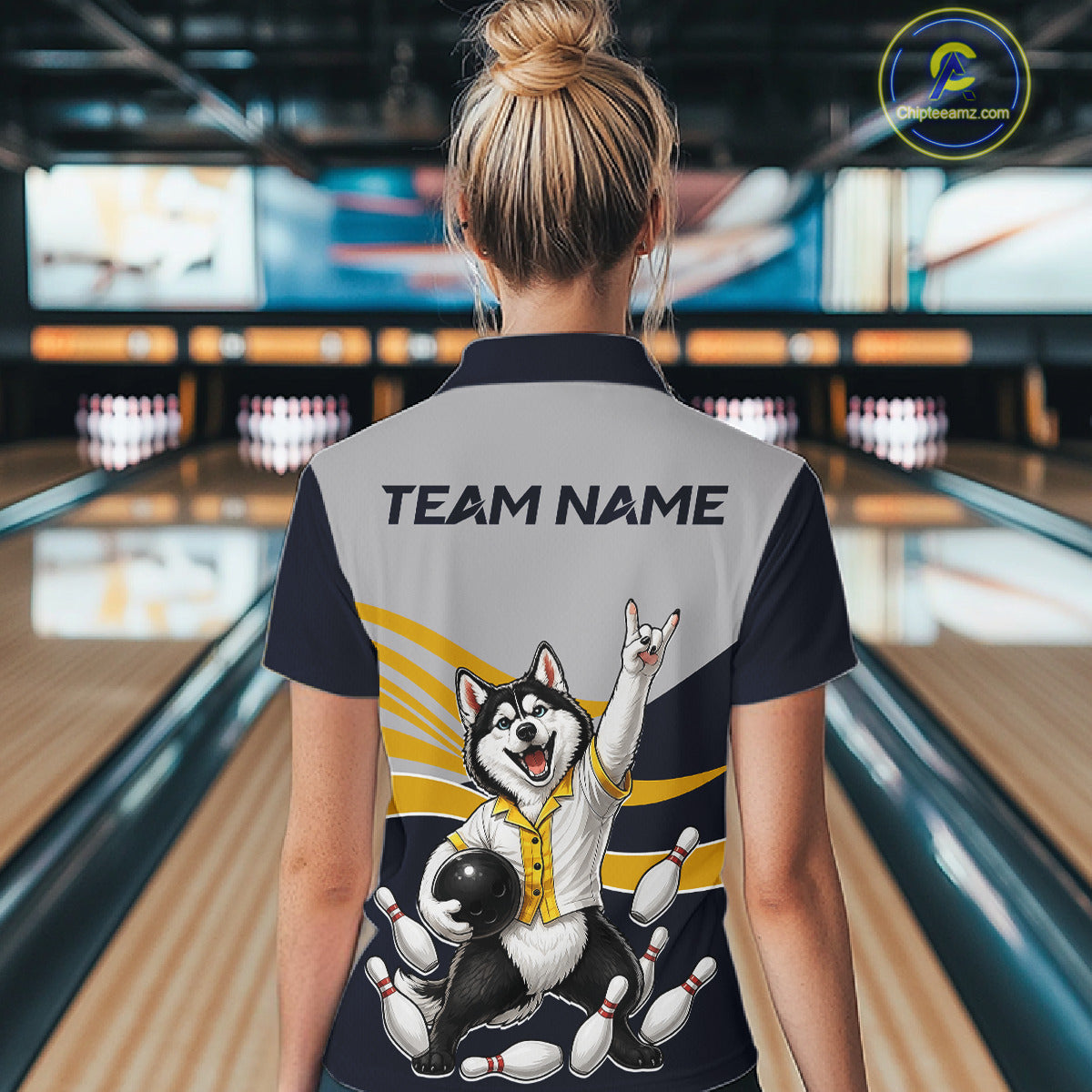 Person wearing a bowling shirt with a dog graphic and 'Team Name' text in a bowling alley.