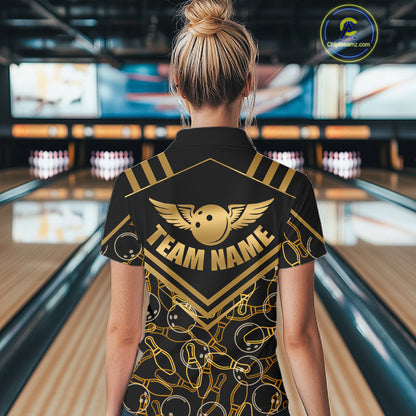 Female model wearing a custom black gold bowling polo shirt back view displaying the personalized team name above a golden winged bowling ball graphic at the bowling alley