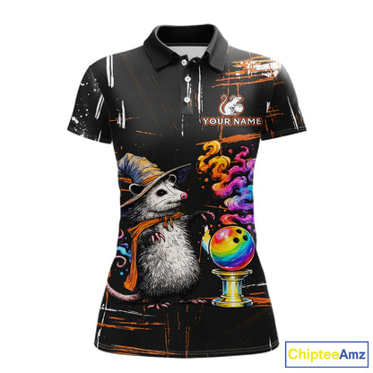A women's short-sleeve polo shirt with a black base and a detailed graphic print featuring a witch opossum wearing a hat and scarf next to a colorful bowling ball, with 'YOUR NAME' placeholder text on the chest.