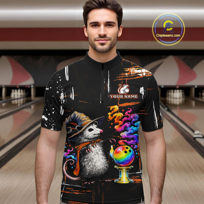 A man wearing a black short-sleeve quarter-zip cycling jersey with a colorful graphic print of a witch opossum and bowling balls, set against a blurred bowling alley background. 