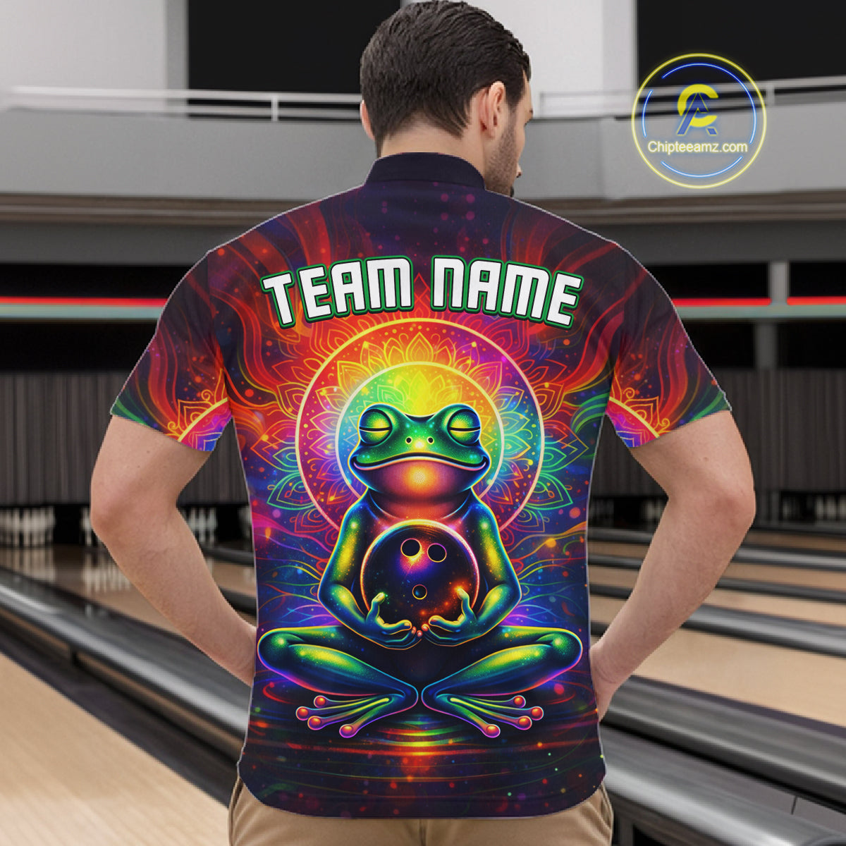 Male model wearing a custom zen frog bowling quarter-zip shirt back view displaying the personalized team name above a vibrant neon frog artwork at the bowling alley