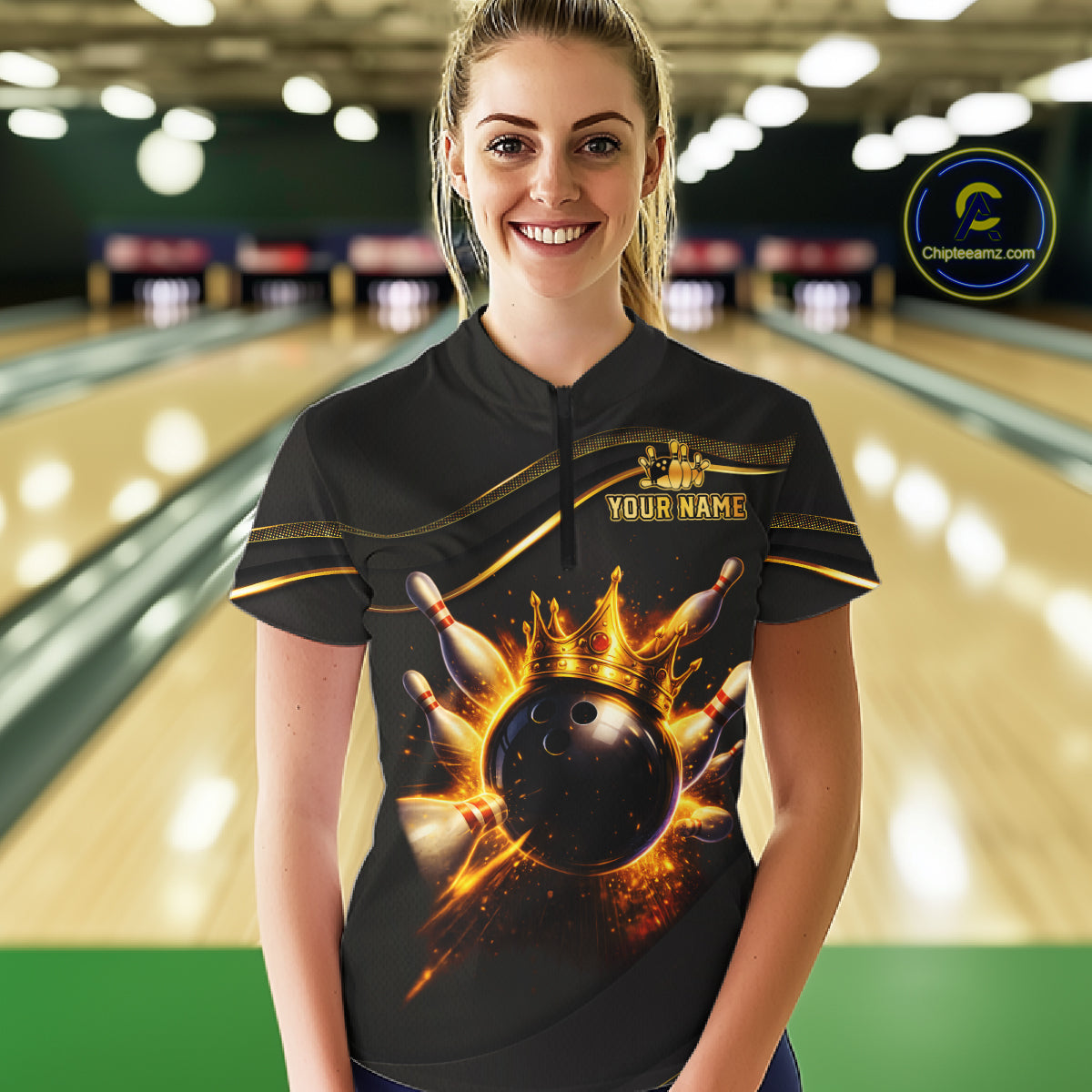A woman wearing a black bowling-themed short-sleeve quarter-zip shirt with a gold crown and bowling ball graphic, standing in a bowling alley. The shirt features 'YOUR NAME' text on the chest and a circular 'Chilewich.