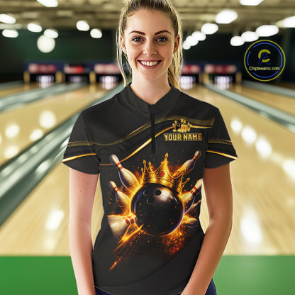 A woman wearing a black bowling-themed short-sleeve quarter-zip shirt with a gold crown and bowling ball graphic, standing in a bowling alley. The shirt features 'YOUR NAME' text on the chest and a circular 'Chilewich.