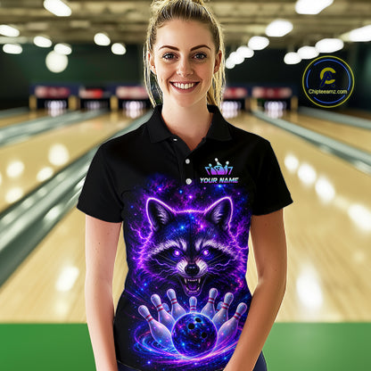 A woman stands in a bowling alley wearing a black short-sleeve polo shirt with a vivid purple and blue graphic of a raccoon surrounded by lightning and bowling pins. The shirt has a custom logo area on the chest and a circular 'Chileenseam.