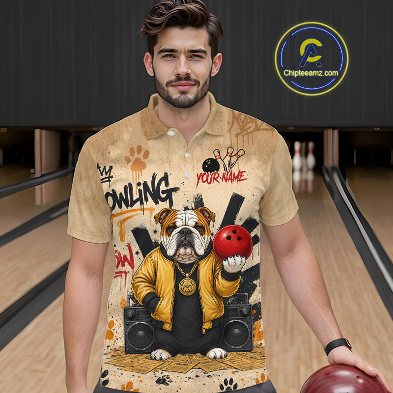 A man wearing a beige short-sleeve polo shirt with a detailed bowling-themed graphic print featuring an bulldog, bowling pins, and a red bowling ball. The background shows bowling lanes, and a 'Chipleamz.