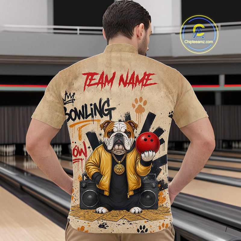 A man viewed from behind wearing a tan short-sleeve button-up shirt with a large bowling-themed graphic on the back. The print includes red 'TEAM NAME' text, black and red 'BOWLING' lettering, a bulldog holding a red bowling ball, speakers, and paw prints.