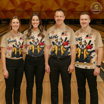 Four people standing together in a bowling alley wearing matching beige graphic bowling shirts with bulldog illustrations and black pants.