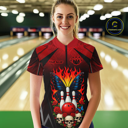 Woman wearing a red and black bowling quarter zip shirt featuring flaming bowling pins, a red bowling ball, a blue butterfly, roses, skulls, and custom player name text.
