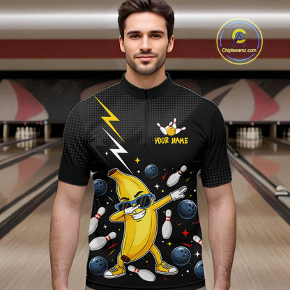 Man wearing a black bowling quarter zip with a cartoon banana character in a bowling alley.