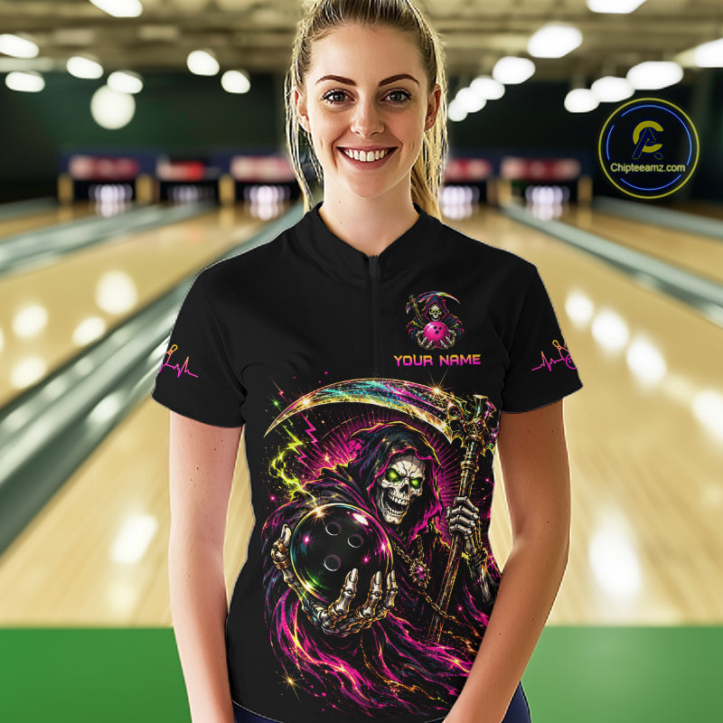 Person wearing a black t-shirt with a colorful graphic design in a bowling alley.