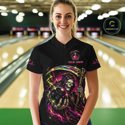 Person wearing a black t-shirt with a colorful graphic design in a bowling alley.