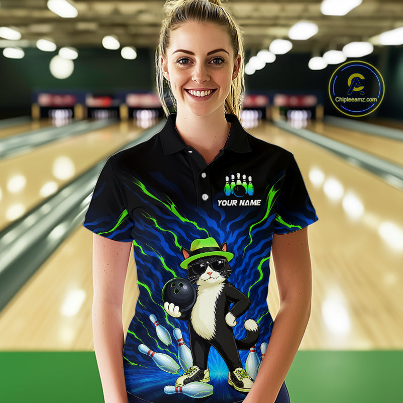 A woman stands in a bowling alley wearing a black short-sleeve polo shirt with a colorful bowling-themed graphic featuring a cat, bowling pins, bowling balls, and neon blue lightning effects. The shirt includes the text 'YOUR NAME' and a visible 'Chilean Seam' watermark/logo on the upper right.