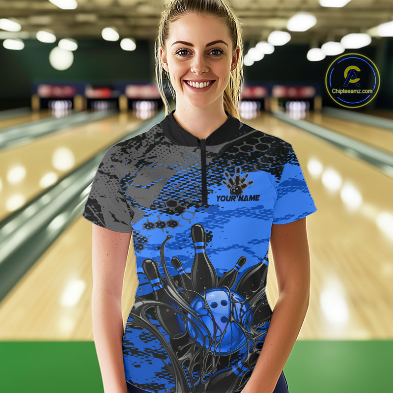 Person wearing a blue and black bowling shirt with 'YOUR NAME' on a bowling alley.
