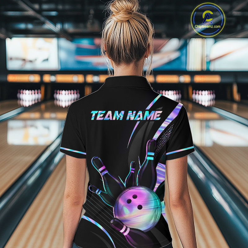 Person wearing a black bowling shirt with colorful designs and 'TEAM NAME' text in a bowling alley.
