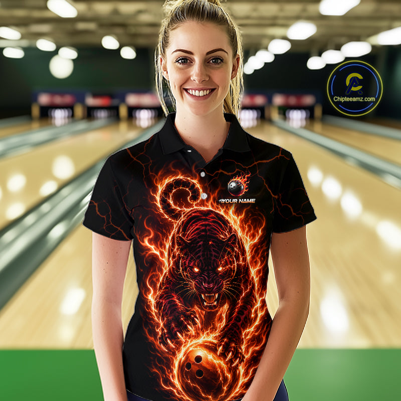 Woman wearing a black shirt with a fiery tiger design in a bowling alley.