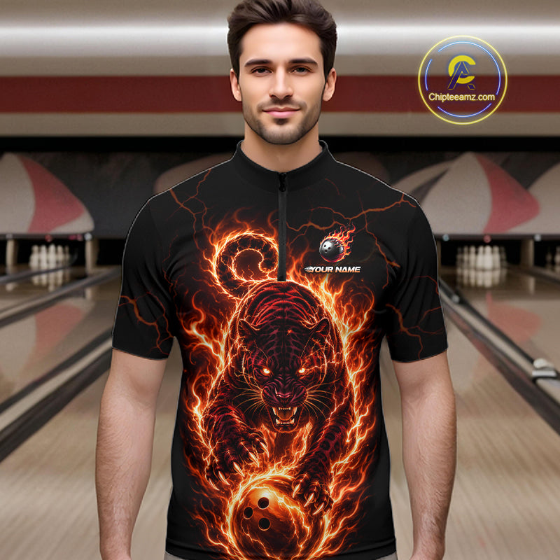 Man wearing a black t-shirt with a fiery panther design in a bowling alley.