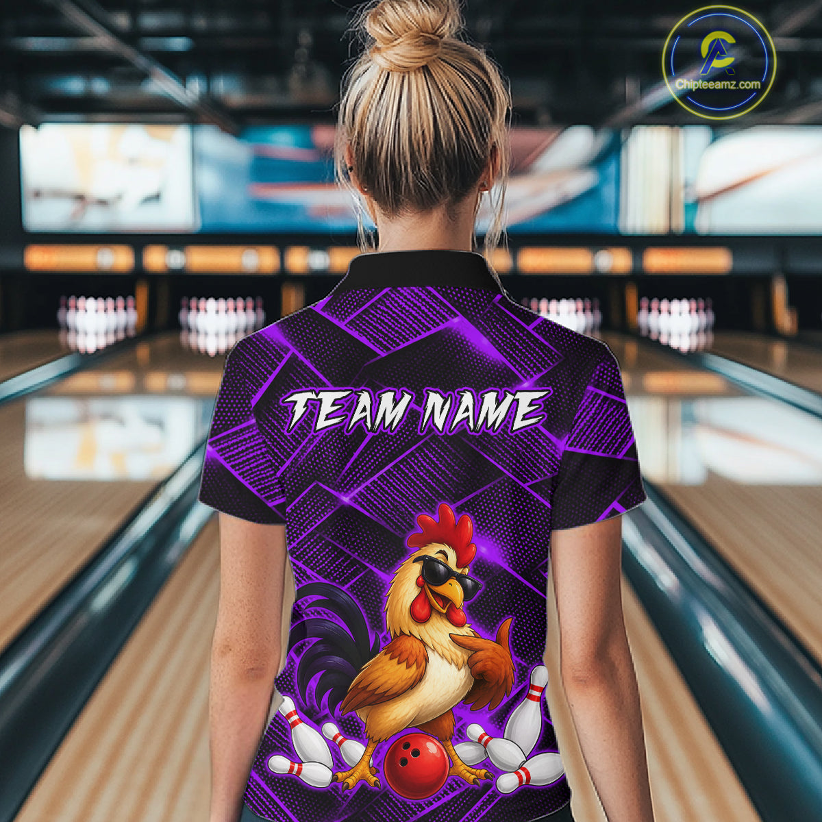 Woman wearing a purple and black bowling quarter zip shirt featuring a cool rooster mascot wearing sunglasses, a red bowling ball, bowling pins, and custom team name text.