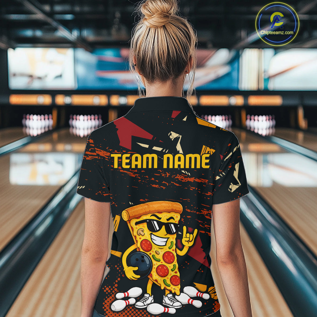 Woman wearing a black bowling polo featuring orange grunge graphics, a sunglasses-wearing pizza slice mascot, bowling pins, and custom team name text.