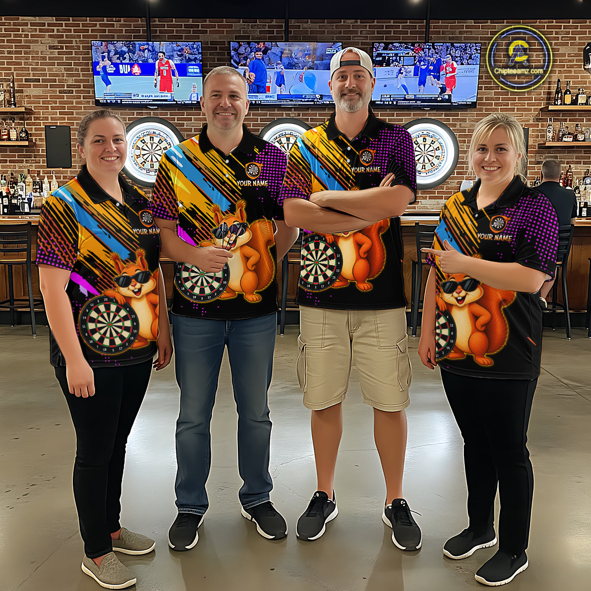 Four people wearing colorful dart-themed shirts in a bar setting with dartboards and televisions in the background.