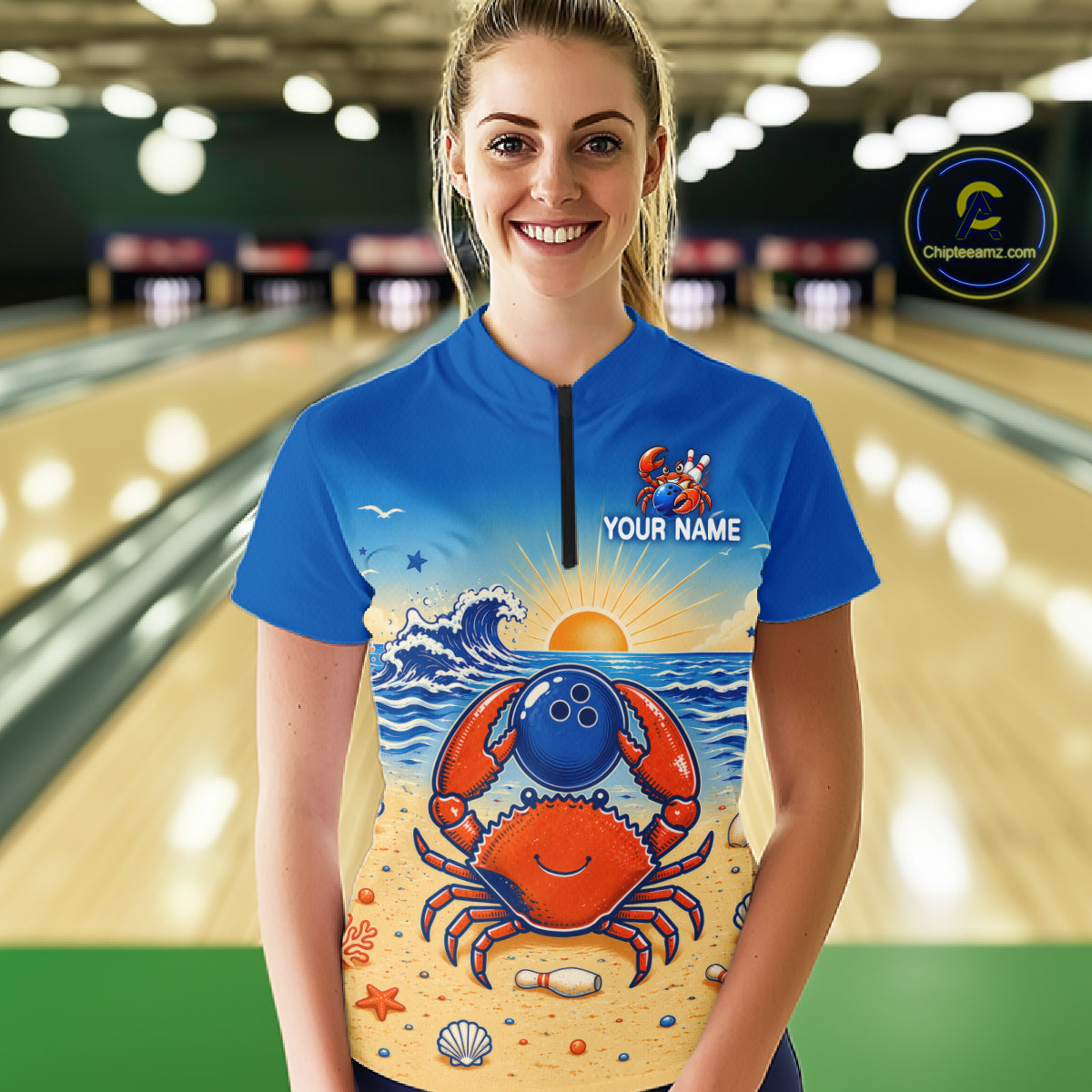 Person wearing a blue shirt with a colorful design of a crab and ocean elements, standing in a bowling alley.
