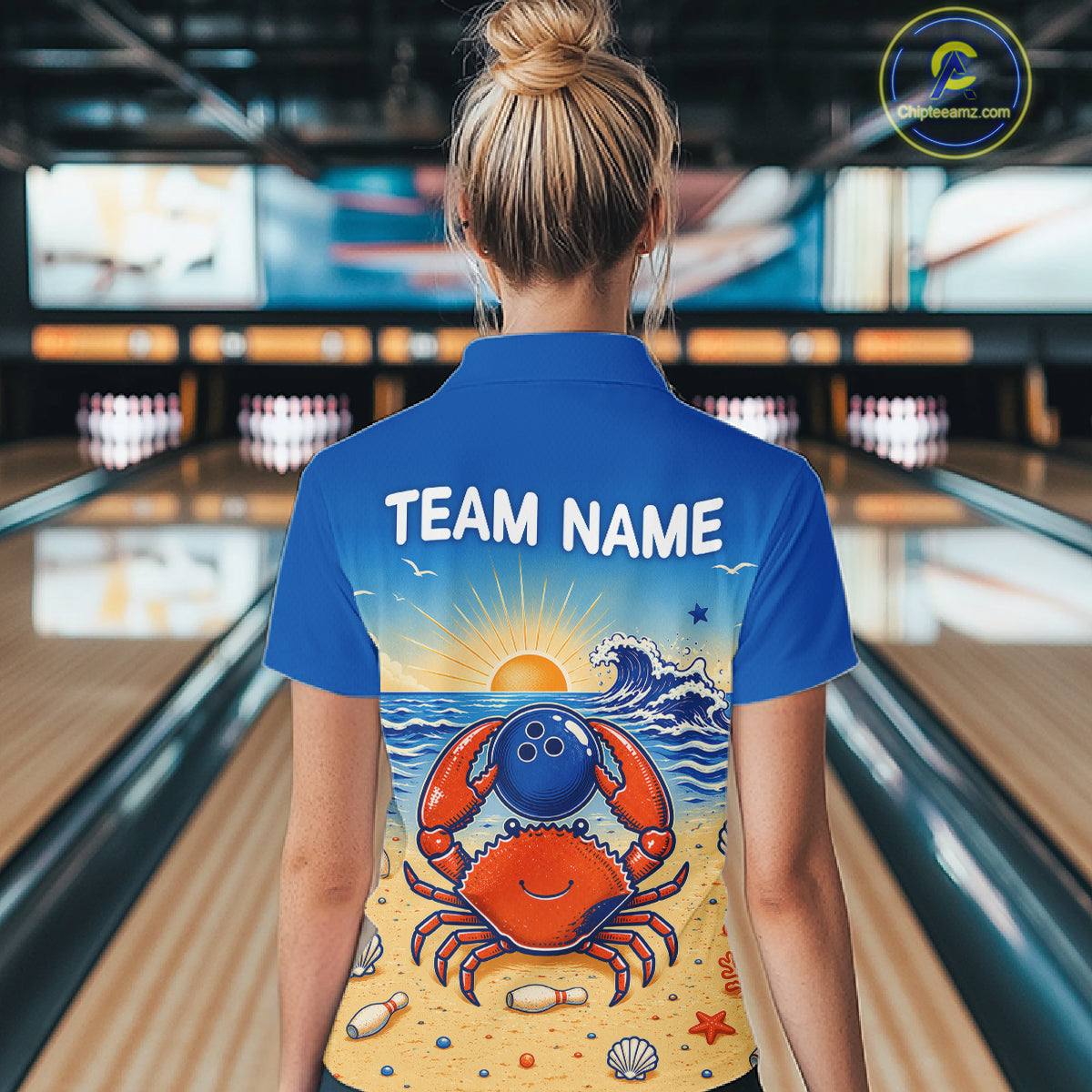Person wearing a blue bowling shirt with a colorful design and 'TEAM NAME' text in a bowling alley.