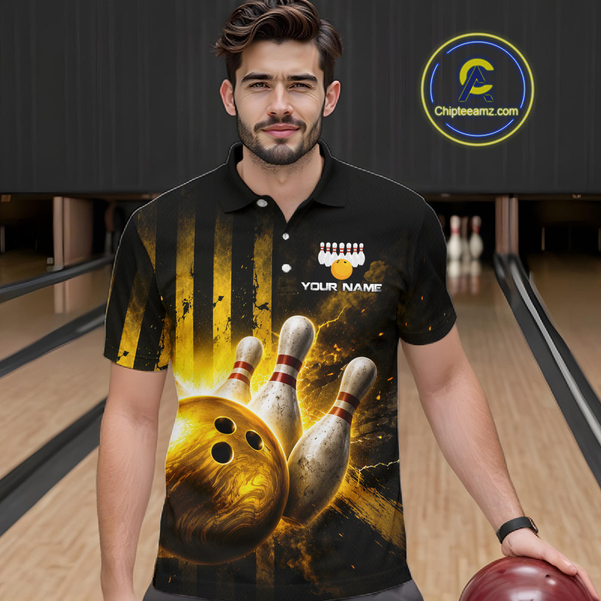 Man wearing a black bowling-themed shirt with a bowling ball and pins design, holding a red bowling ball in a bowling alley.