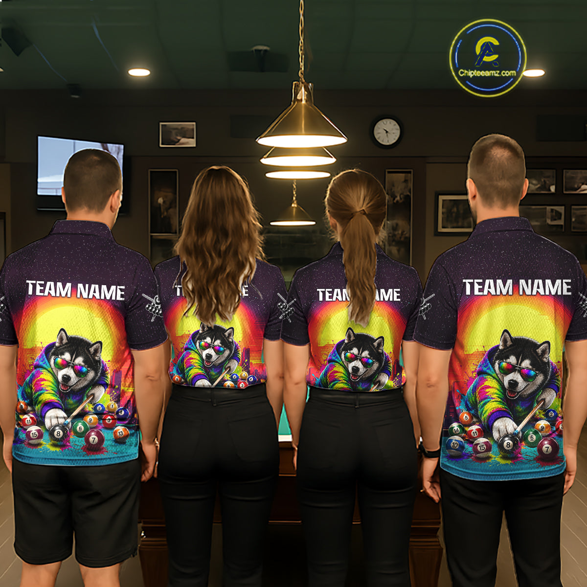 Four people wearing matching shirts with a colorful design of a dog playing pool in a bar setting.