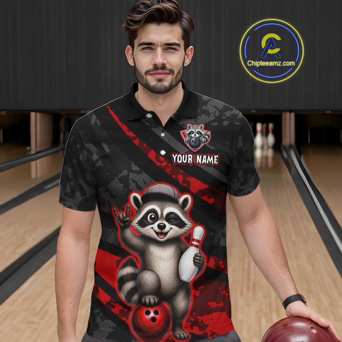 Man wearing a black and red bowling-themed shirt with a raccoon graphic on a bowling alley.