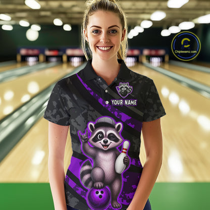 Person wearing a custom bowling shirt with a raccoon design in a bowling alley.