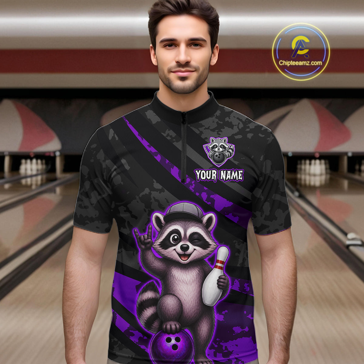Man wearing a black and purple bowling shirt with a raccoon design in a bowling alley.