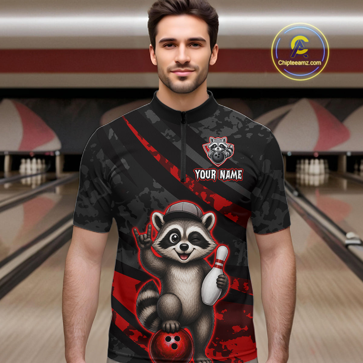 Man wearing a black bowling shirt with a raccoon graphic in a bowling alley.
