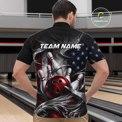 A man viewed from behind wearing a black short-sleeve bowling-themed shirt with a large graphic print of bowling pins, a red bowling ball, an American flag, and the text 'TEAM NAME'. The background shows bowling lanes in a bowling alley.
