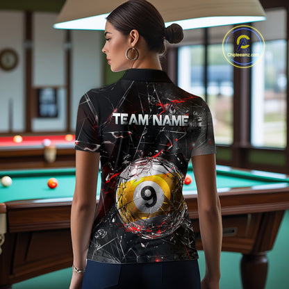 Woman wearing a black collared polo shirt with shattered glass graphics, red accent streaks, a custom name area, and a large cracked 9-ball illustration across the lower back.