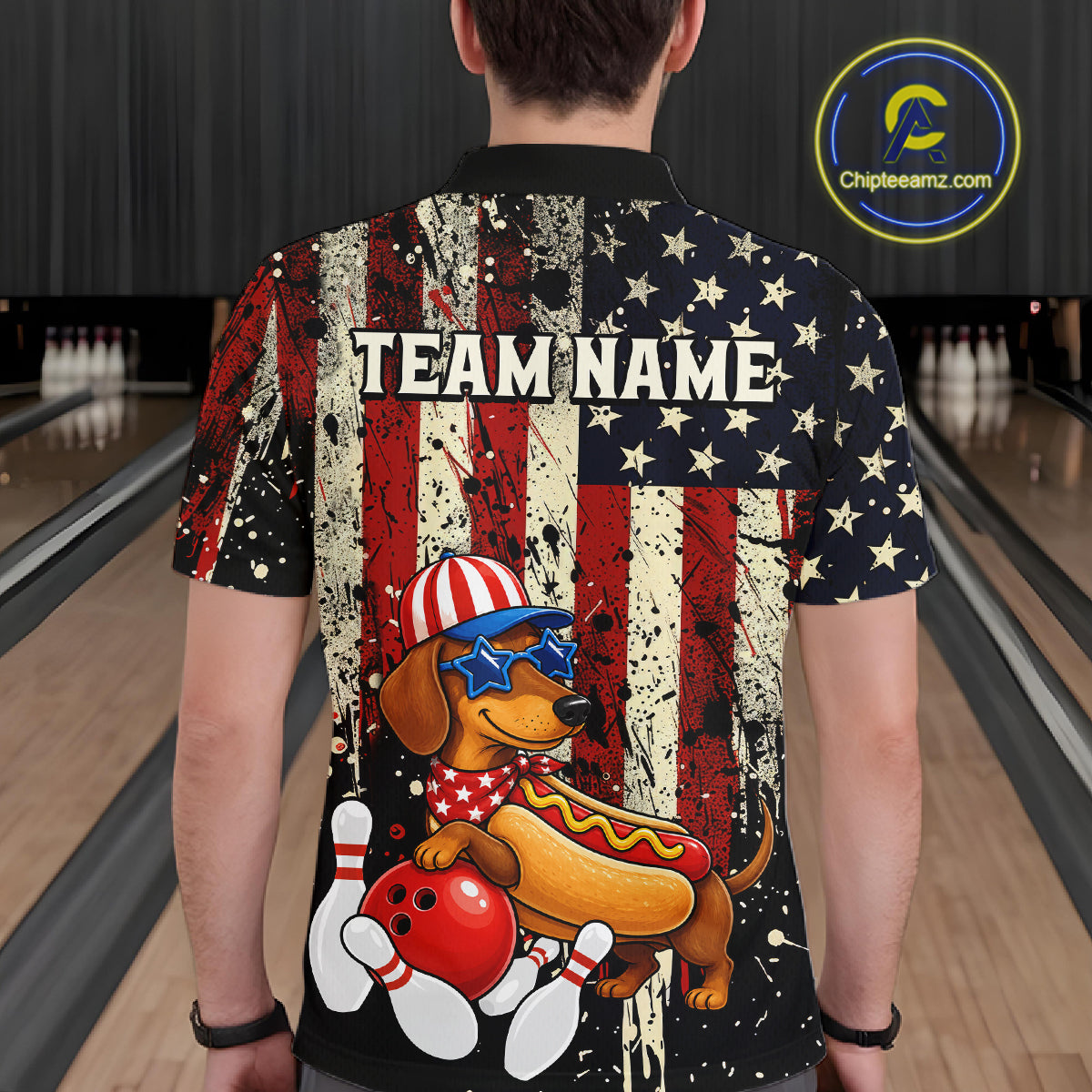 Person wearing a colorful shirt with a dog and hot dog design in a bowling alley.