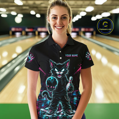 A woman stands in a bowling alley wearing a black short-sleeve polo shirt with a colorful neon cat graphic and the text 'YOUR NAME' on the chest. Bowling lanes are blurred in the background, and a circular 'Chippewanz.