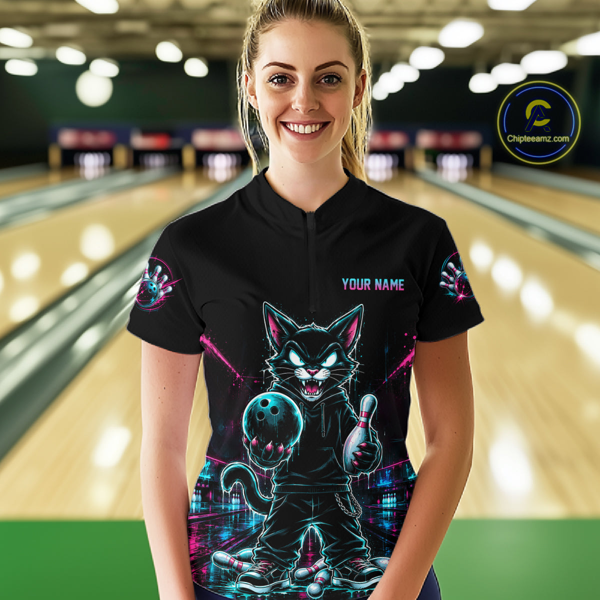 A woman stands in a bowling alley wearing a black short-sleeve bowling shirt with a colorful neon cat graphic and the text 'YOUR NAME' on the chest. A circular 'ChicStyles.