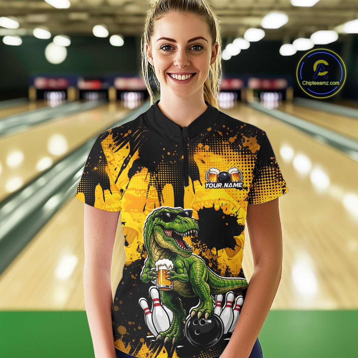 Women wearing bowling quarter zip shirt featuring a dinosaur holding beer with bowling pins and ball artwork on black yellow background.